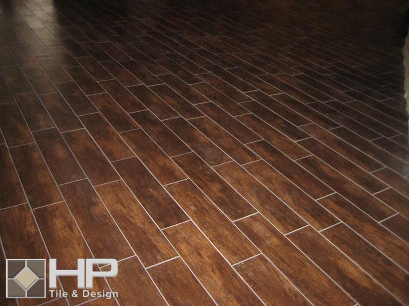 Dark brown, wood-look tile flooring with white grout lines, installed in a diagonal pattern
