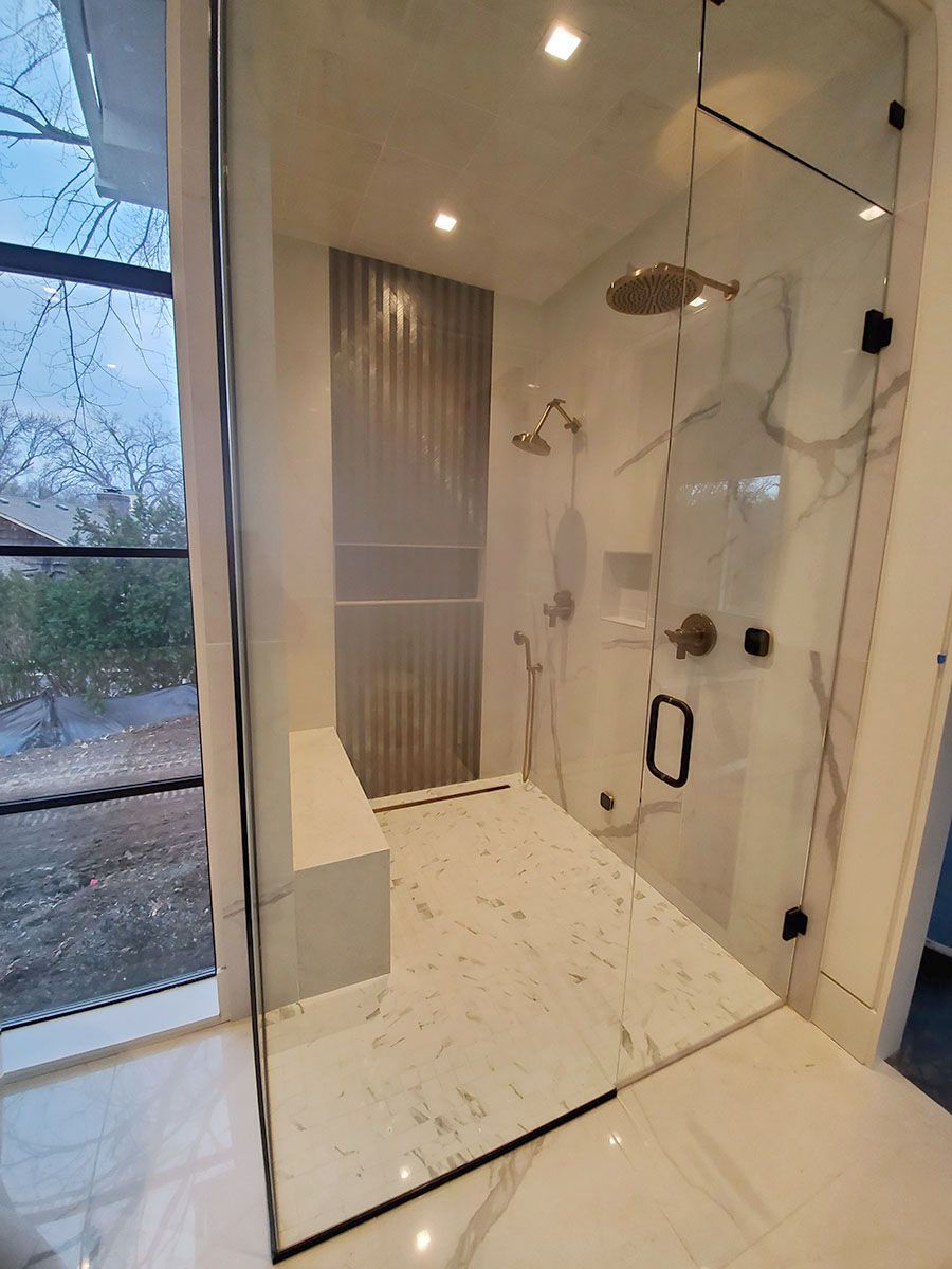 Modern shower with marble tile, glass enclosure, and rain showerhead