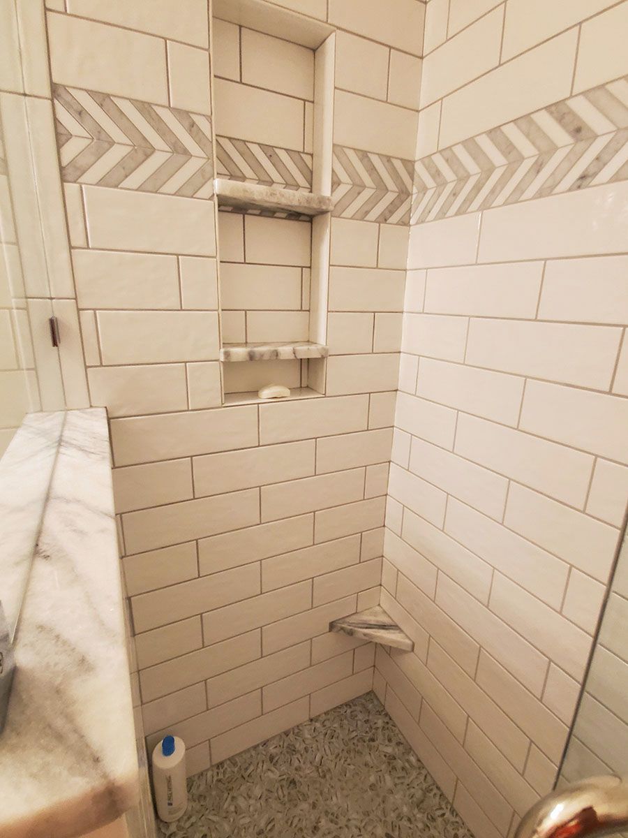 Tiled shower with built-in shelf and decorative tile border