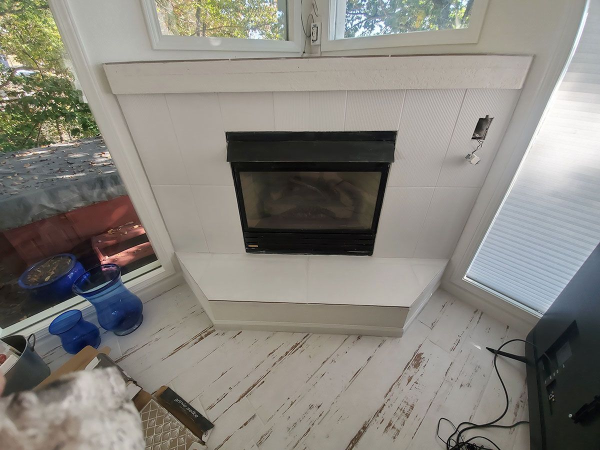 Fireplace with white paneling and a black firebox, set into a wall with windows on either side