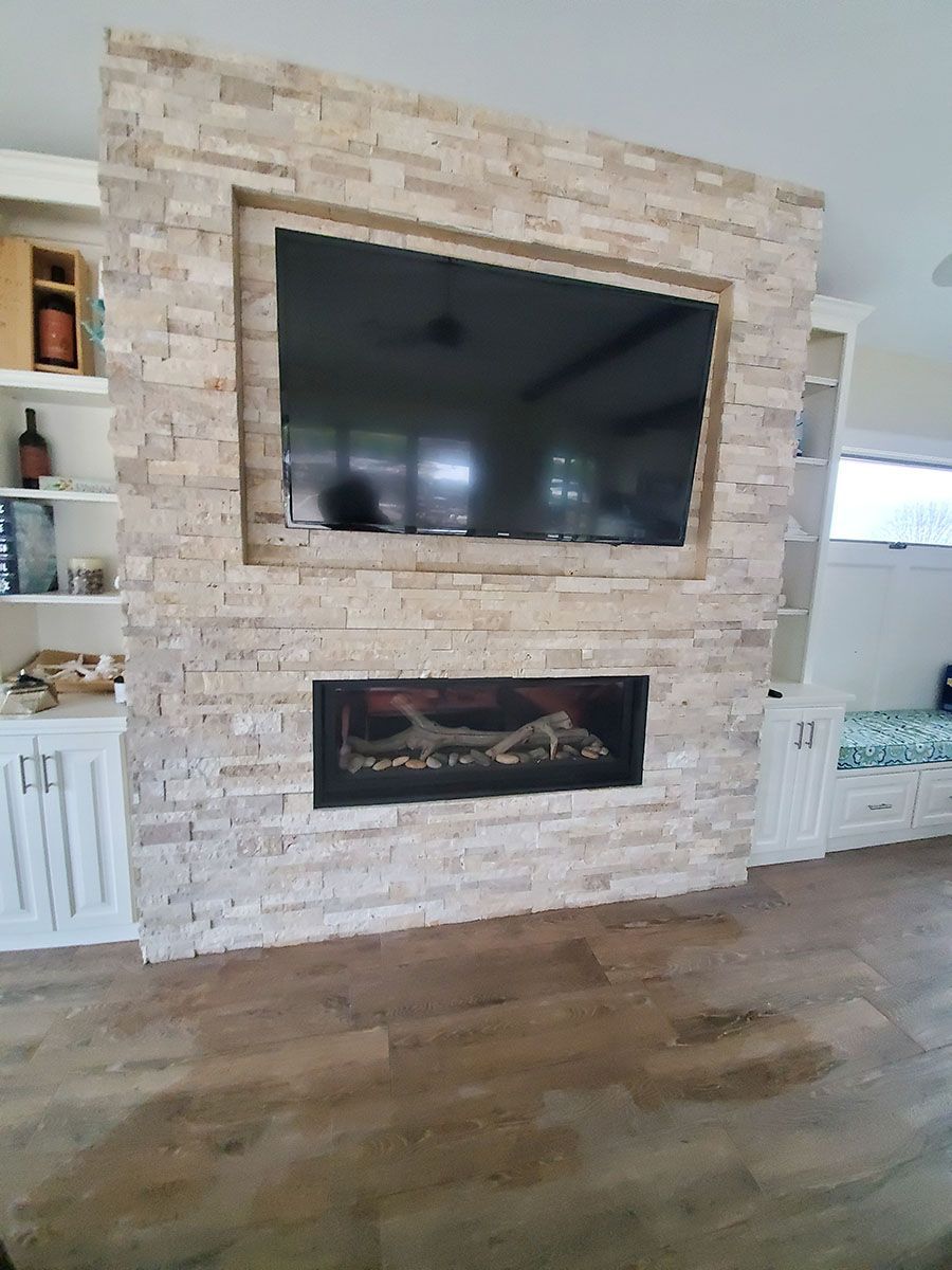 Stone accent wall with mounted TV and fireplace