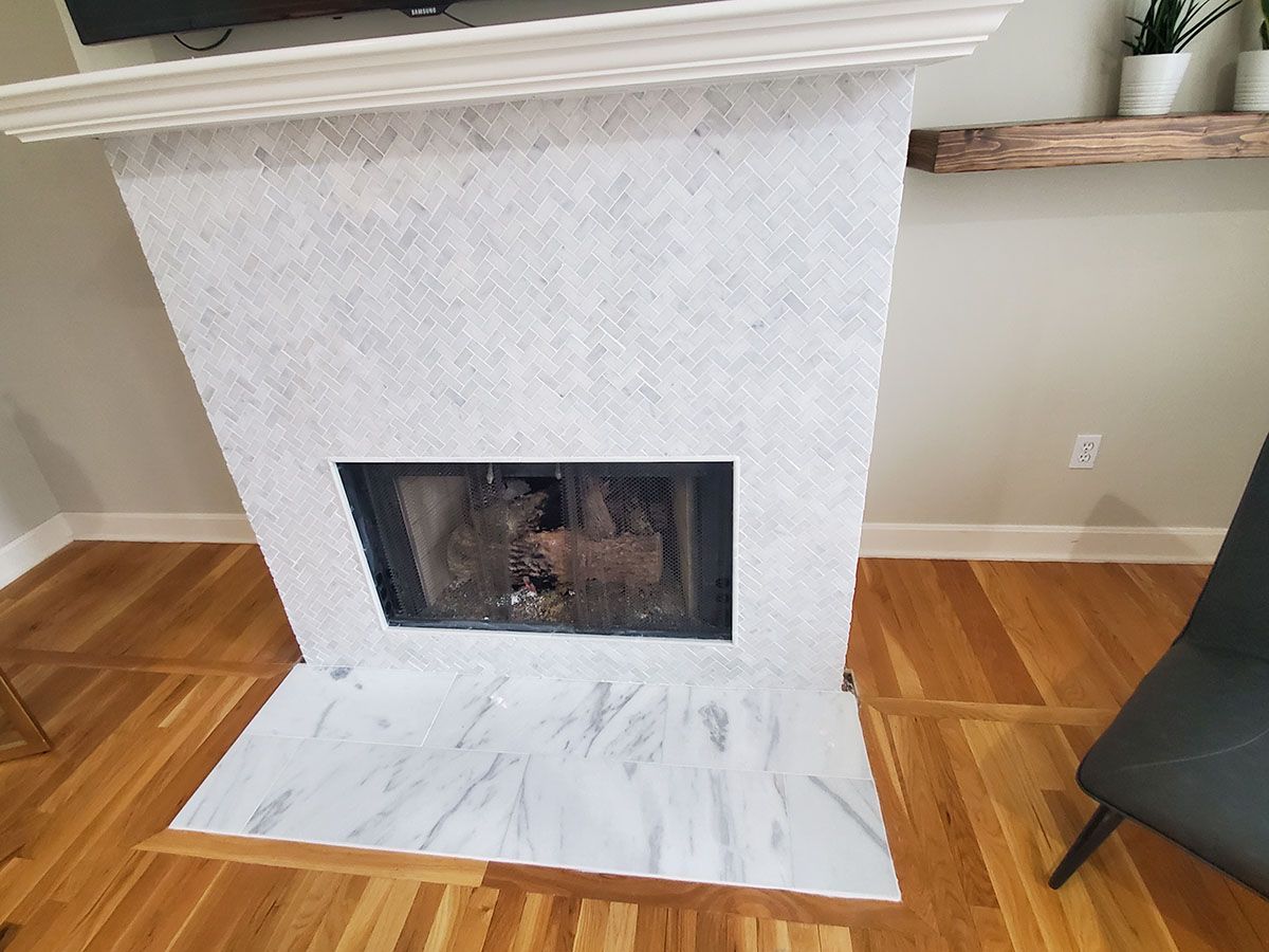 White tiled fireplace with marble hearth and wood flooring