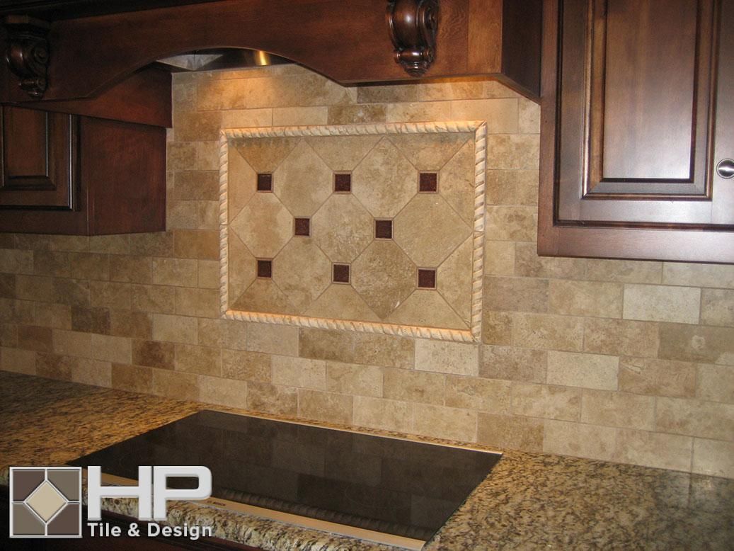 Kitchen backsplash with beige tile, inset with decorative brown squares, granite countertop, and dark wood cabinets.