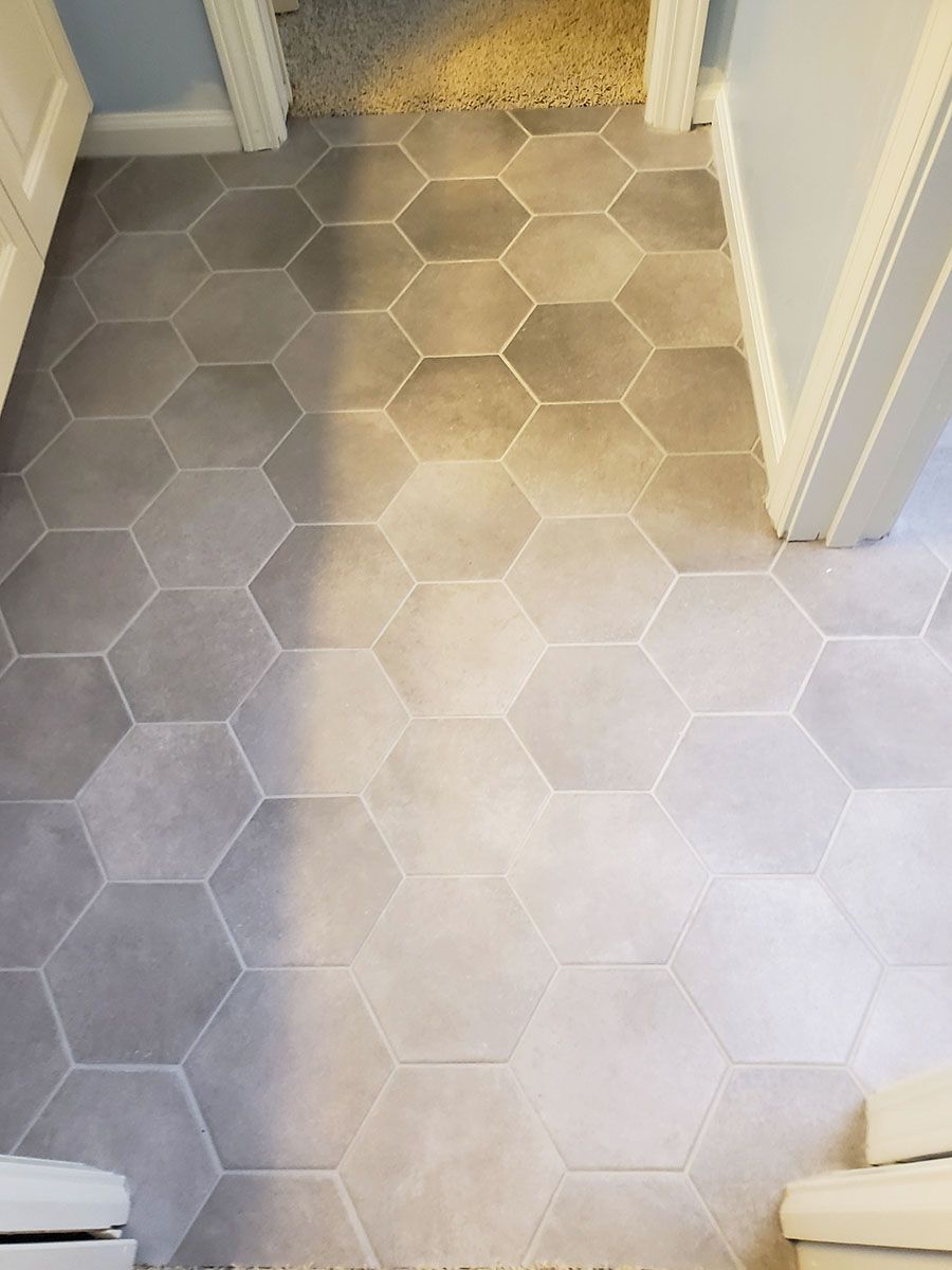 Gray hexagonal tiles on a floor, leading into a room