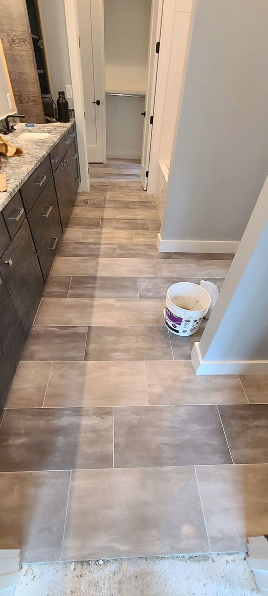 Bathroom with wood-look tile flooring leading to a hallway