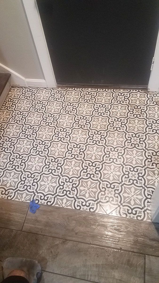 Patterned tile flooring in a doorway. Black, white, and gray geometric design