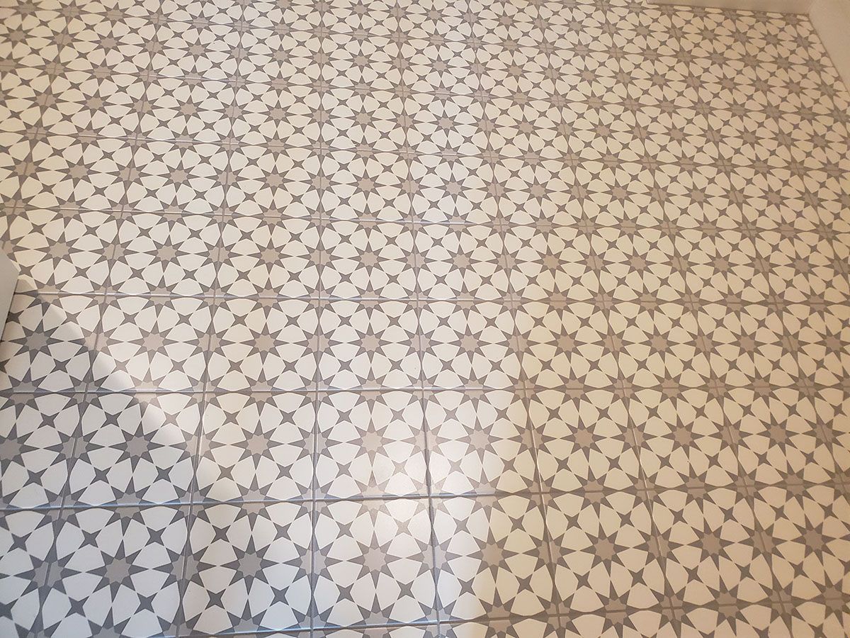 Patterned floor tiles featuring gray and white star-like designs
