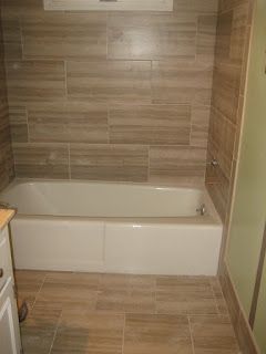 Bathtub in a bathroom with wood-look tile walls and floor