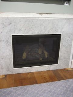 Fireplace with marble surround and wooden hearth.
