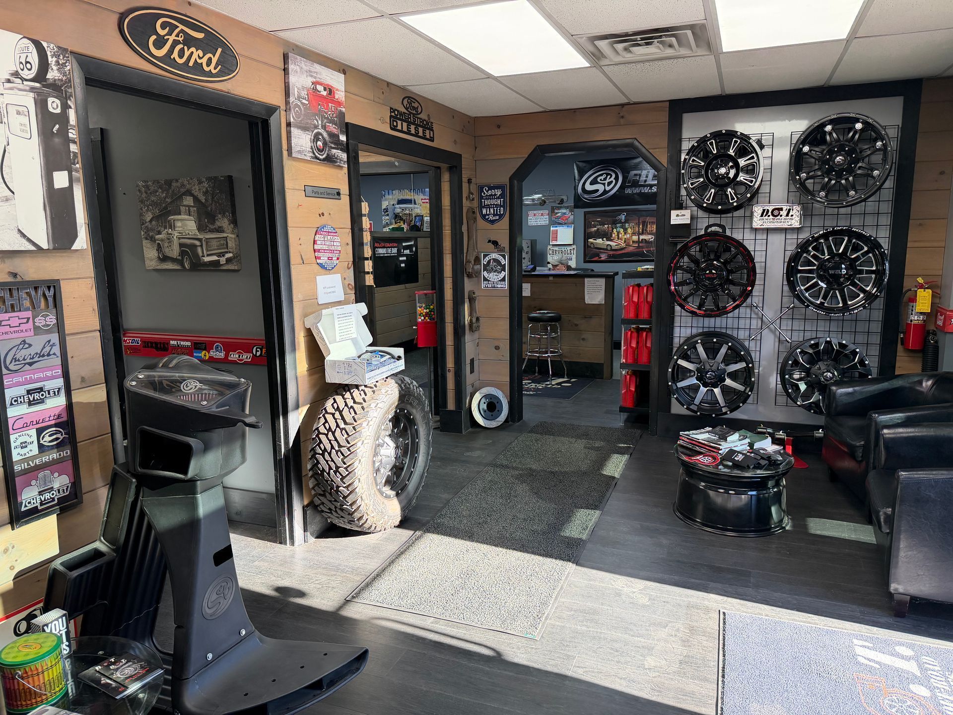 Auto shop lobby with wheel displays, a front desk, and a Ford sign