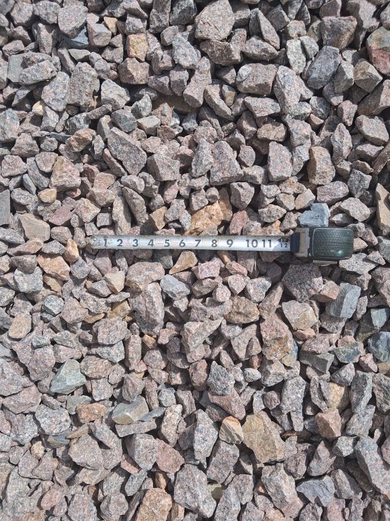 A tape measure is sitting on top of a pile of rocks.