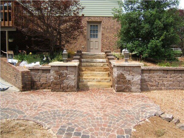A house with a brick walkway and stone steps leading to the back door