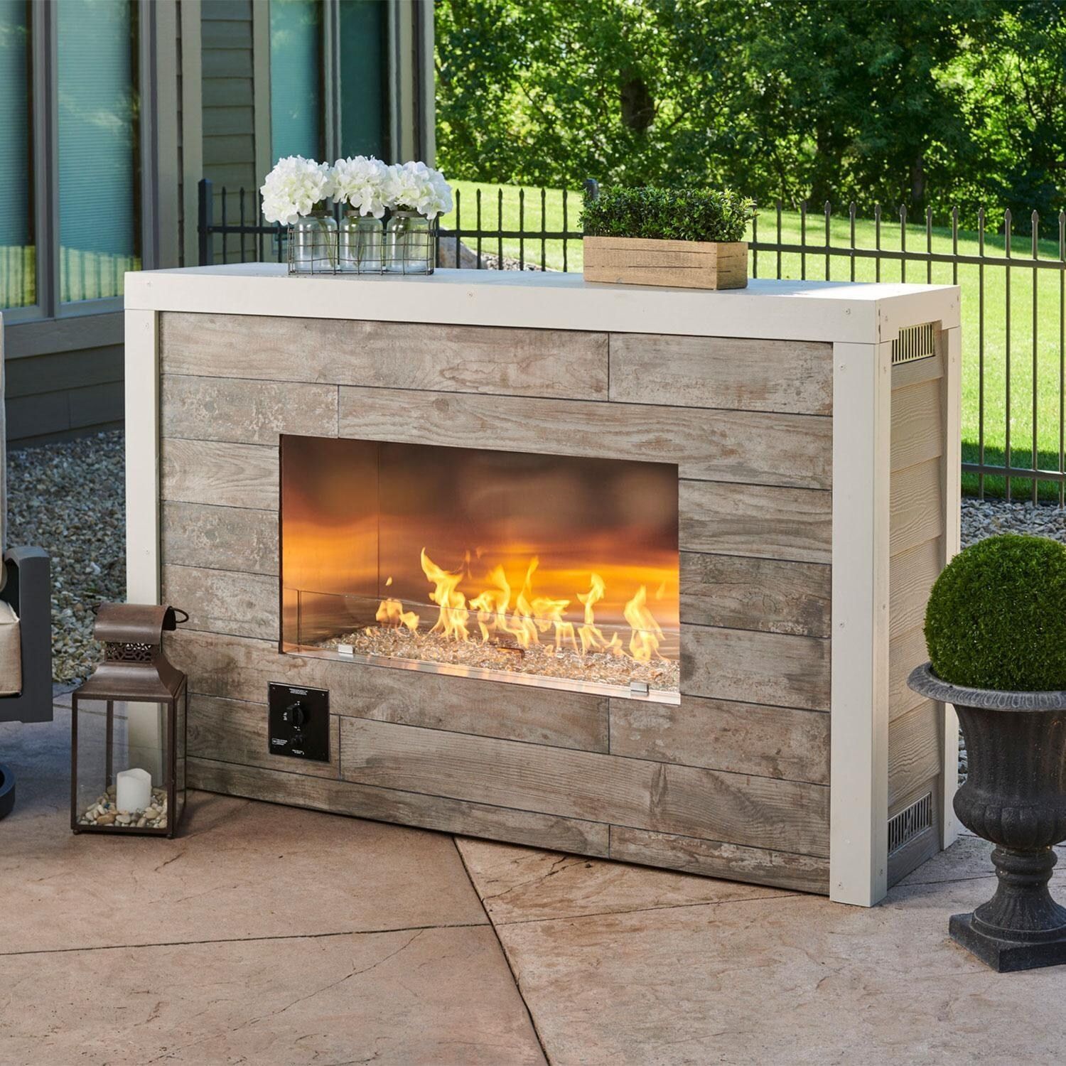 A fireplace with flames coming out of it on a patio