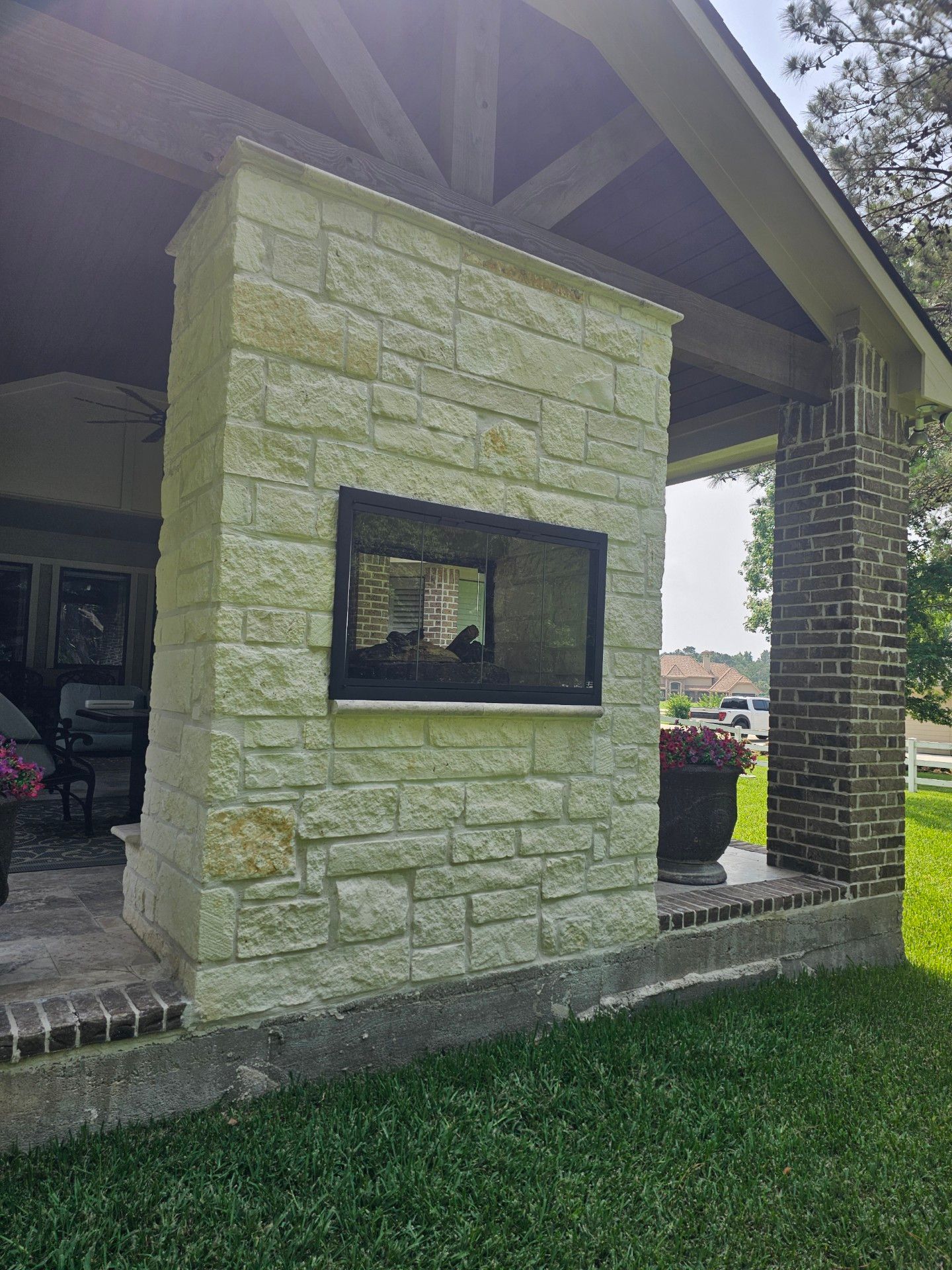 A brick fireplace is built into the side of a house.