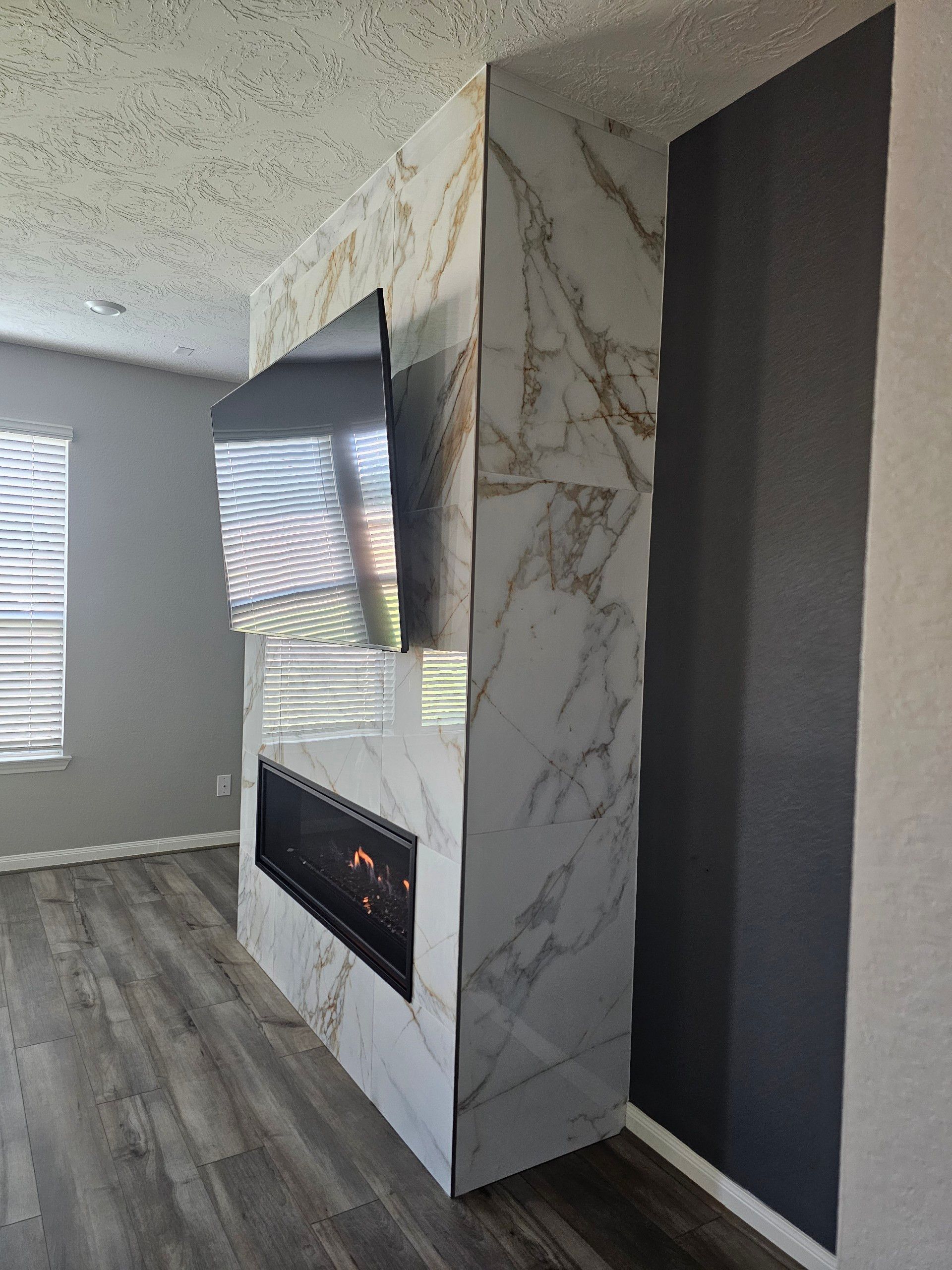 A living room with a fireplace and a flat screen tv.