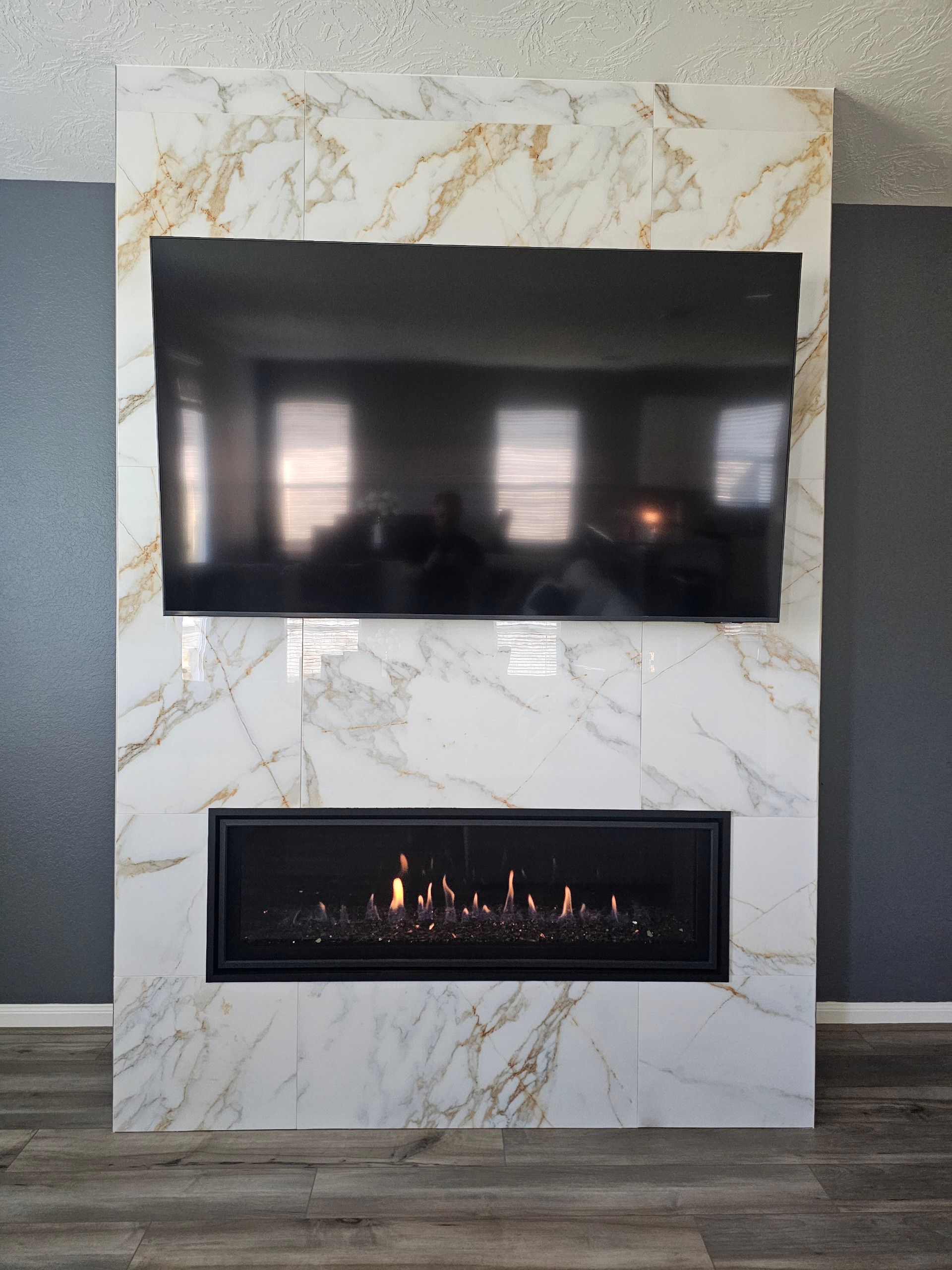 A fireplace with a flat screen tv mounted above it.