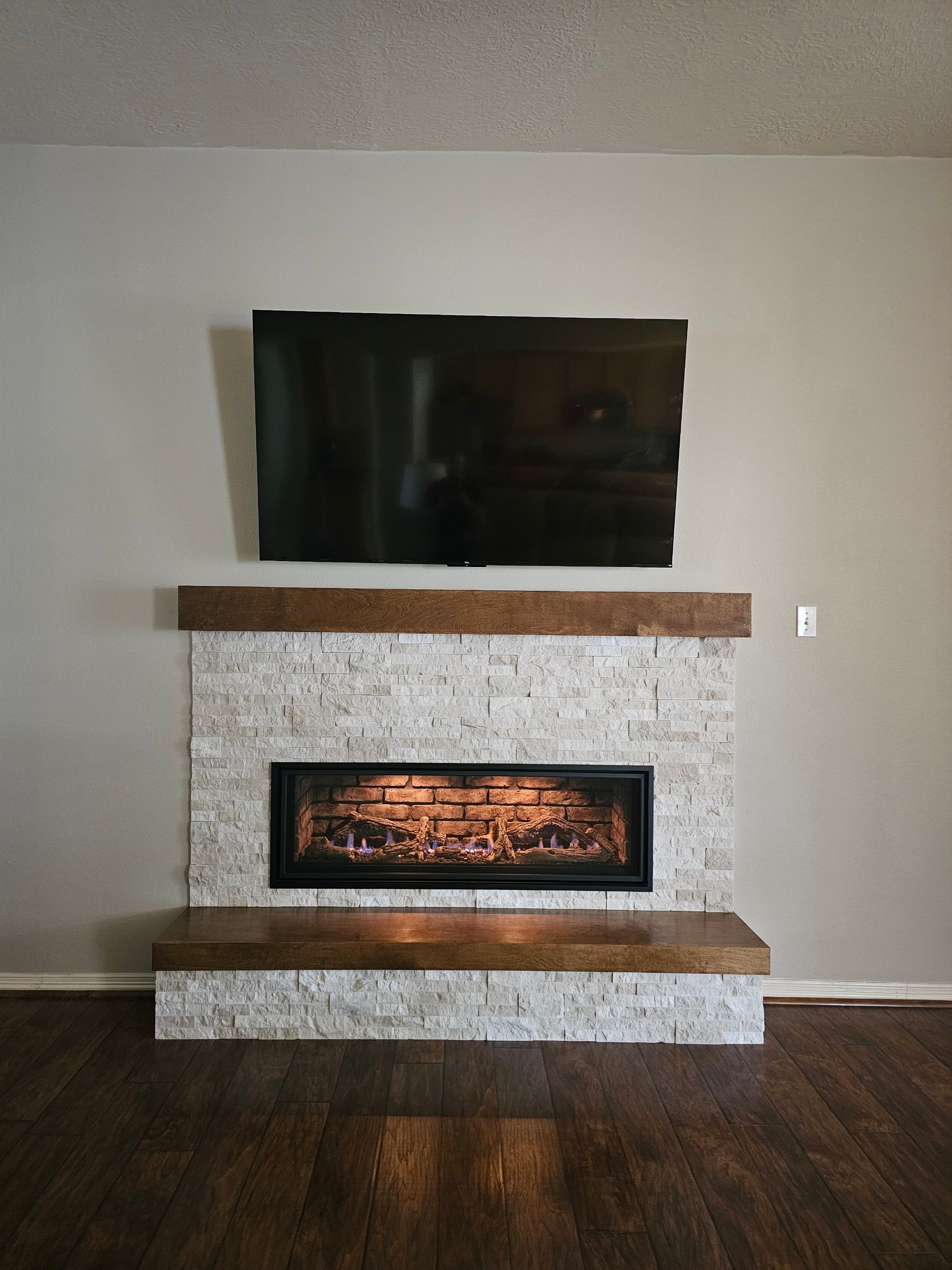 A fireplace with a flat screen tv above it in a living room.