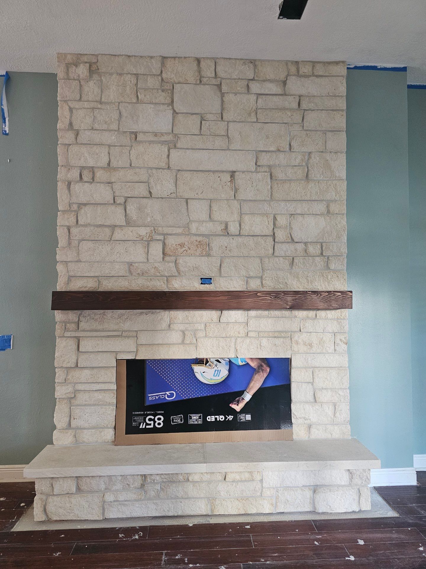 A brick fireplace in a living room with a clock on it
