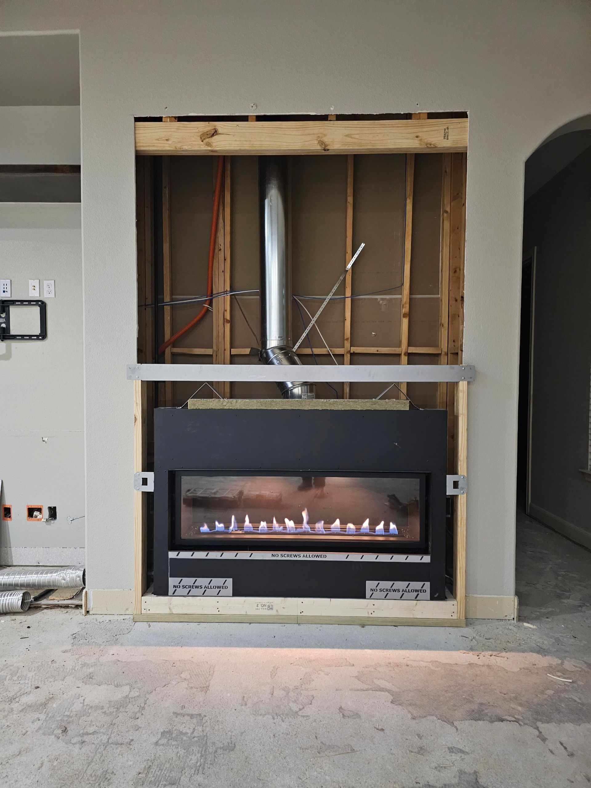 A fireplace is being built into a wall in a room