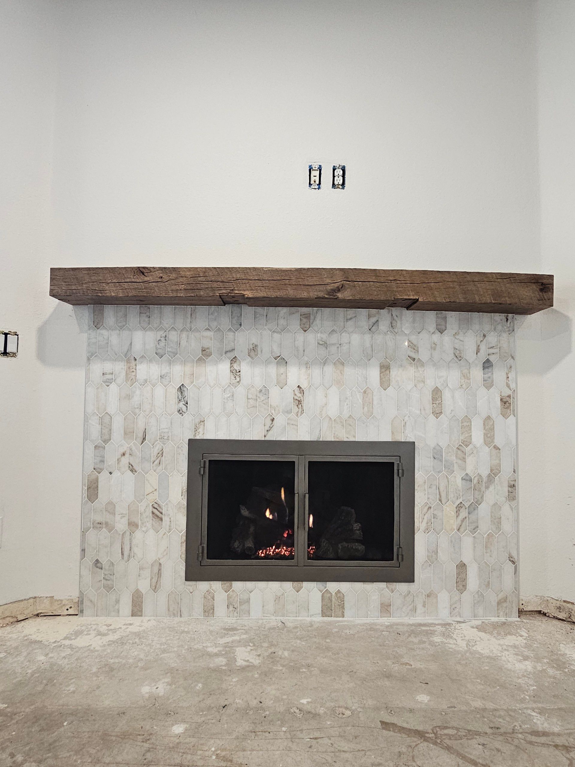 A fireplace with a wooden mantle in a living room.