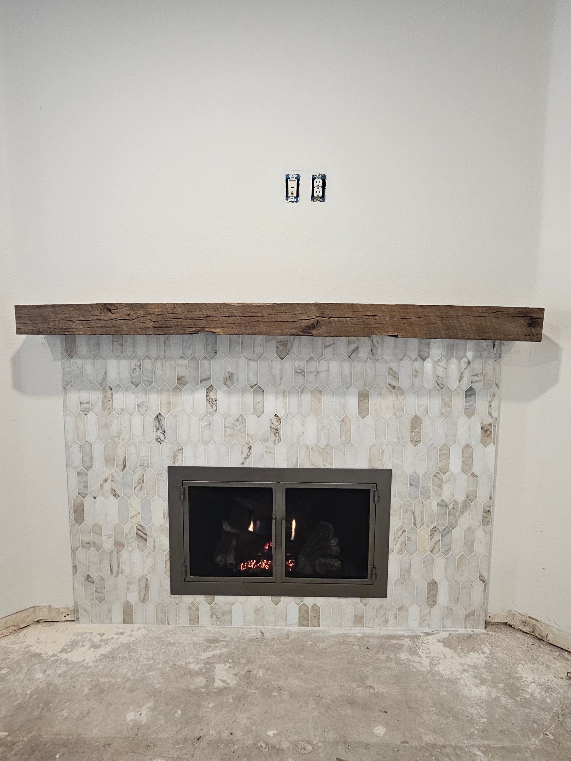 A fireplace with a wooden mantle in a living room.