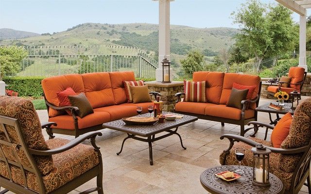 A patio with a couch , chairs , and a coffee table.
