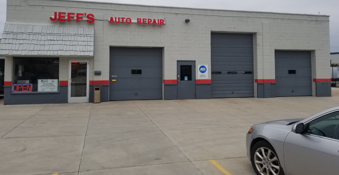 Jeff's Auto Repair shop with a gray facade, three garage doors, and a car parked in front.