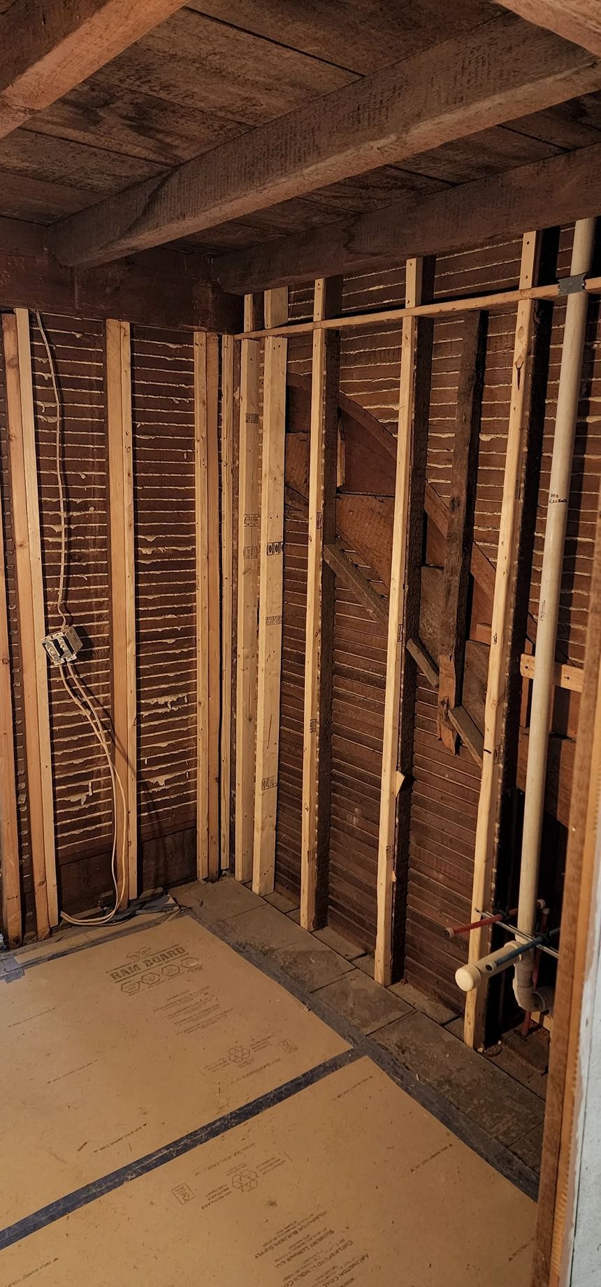 A room with a brick wall and wooden beams.