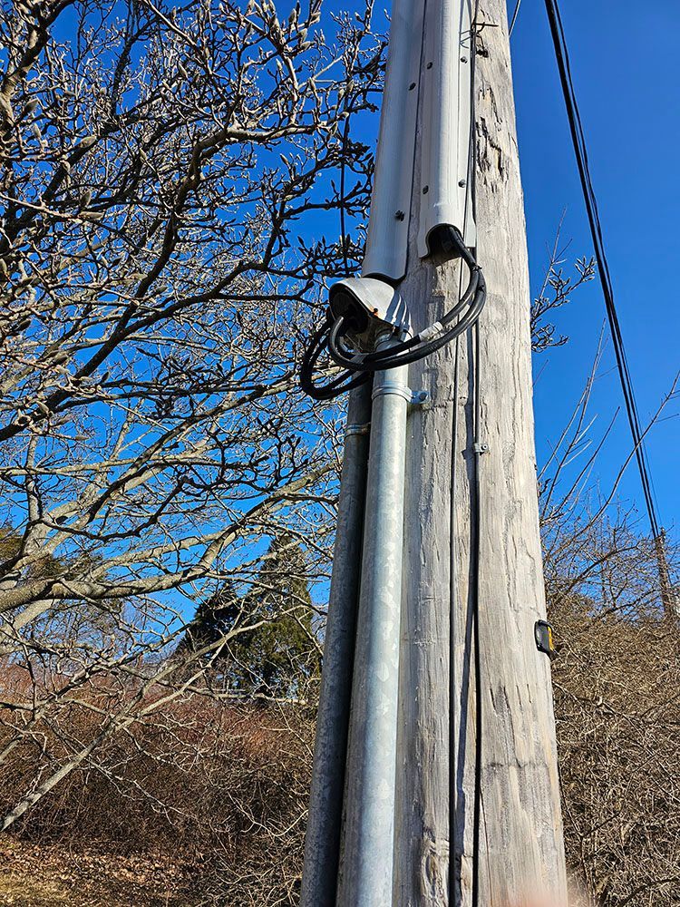 A wooden pole with a bunch of wires attached to it.