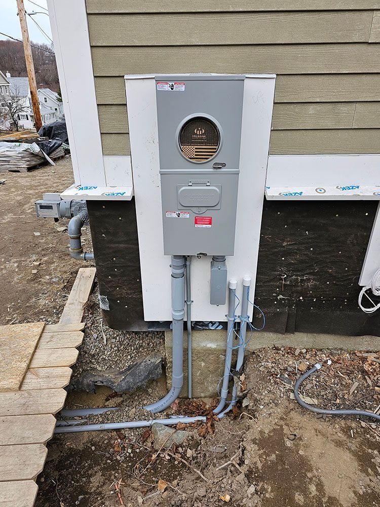 An electrical box is installed on the side of a house.