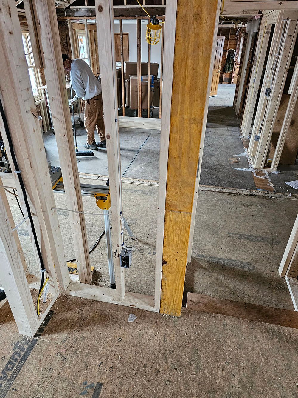 A man is standing in a room in a house under construction.