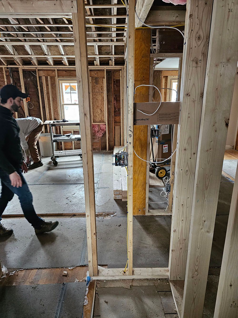 A man is walking through a building under construction.