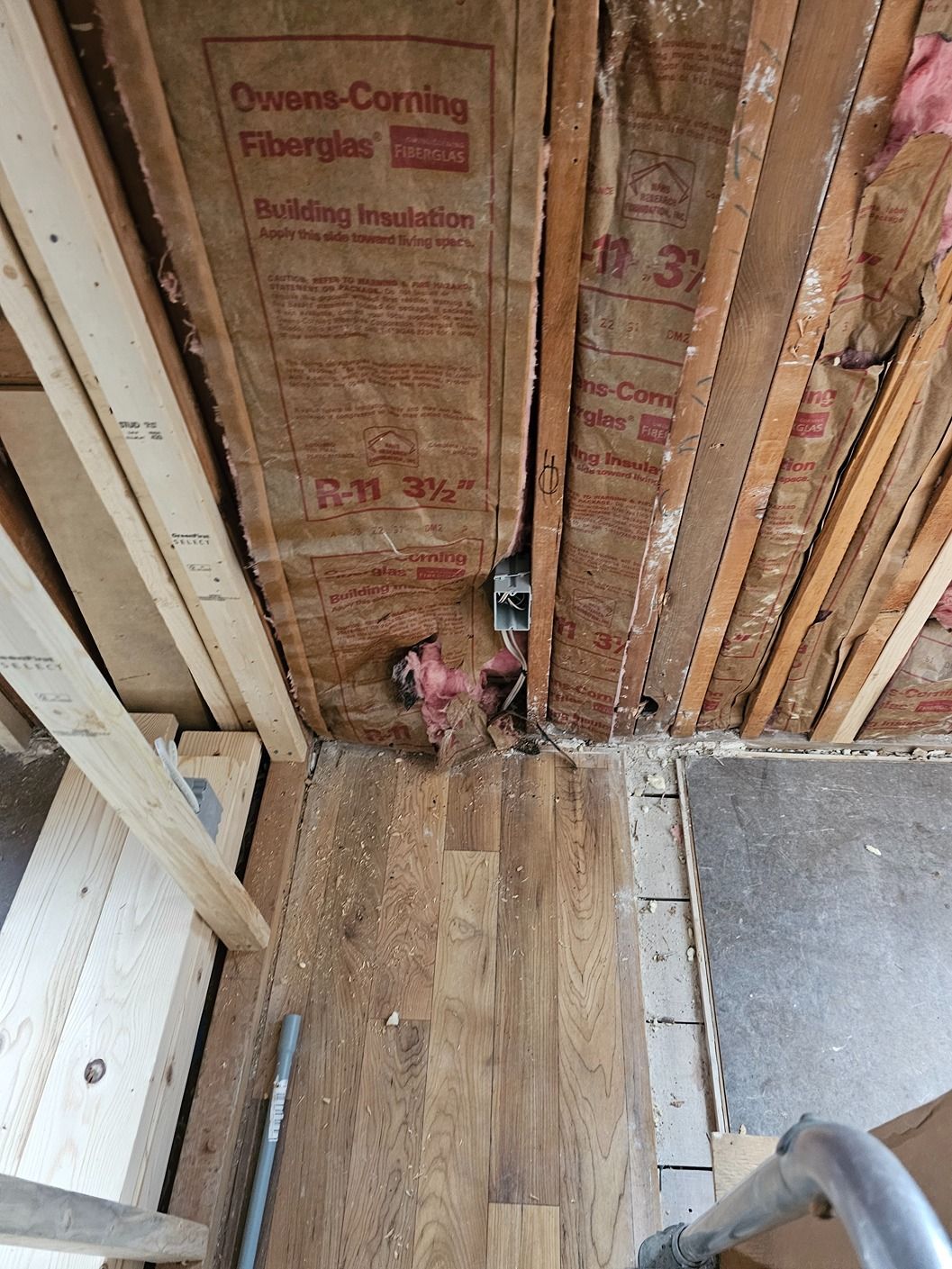 A box of insulation is sitting on the floor of a building under construction.