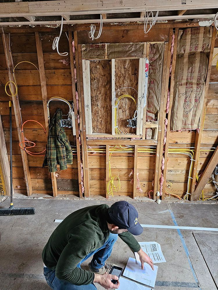A man is kneeling down in a room looking at a piece of paper.