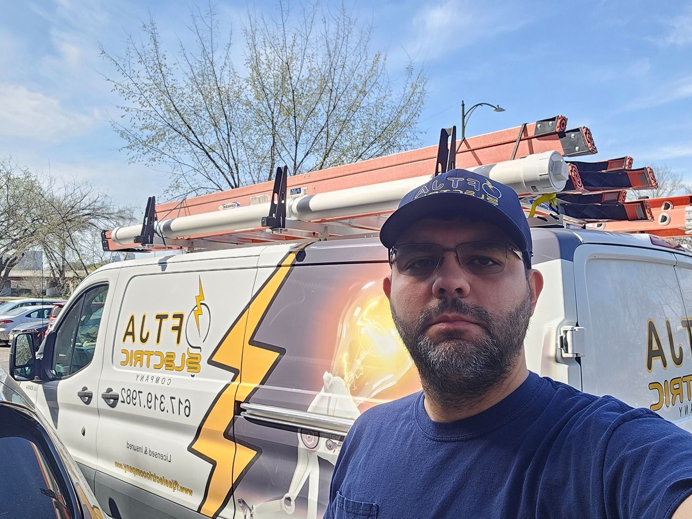 A man is standing in front of a van with a lightning bolt on it.