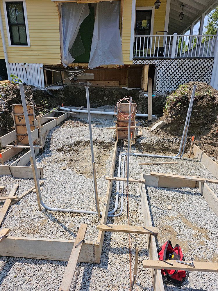 A house is being built on top of a gravel lot.