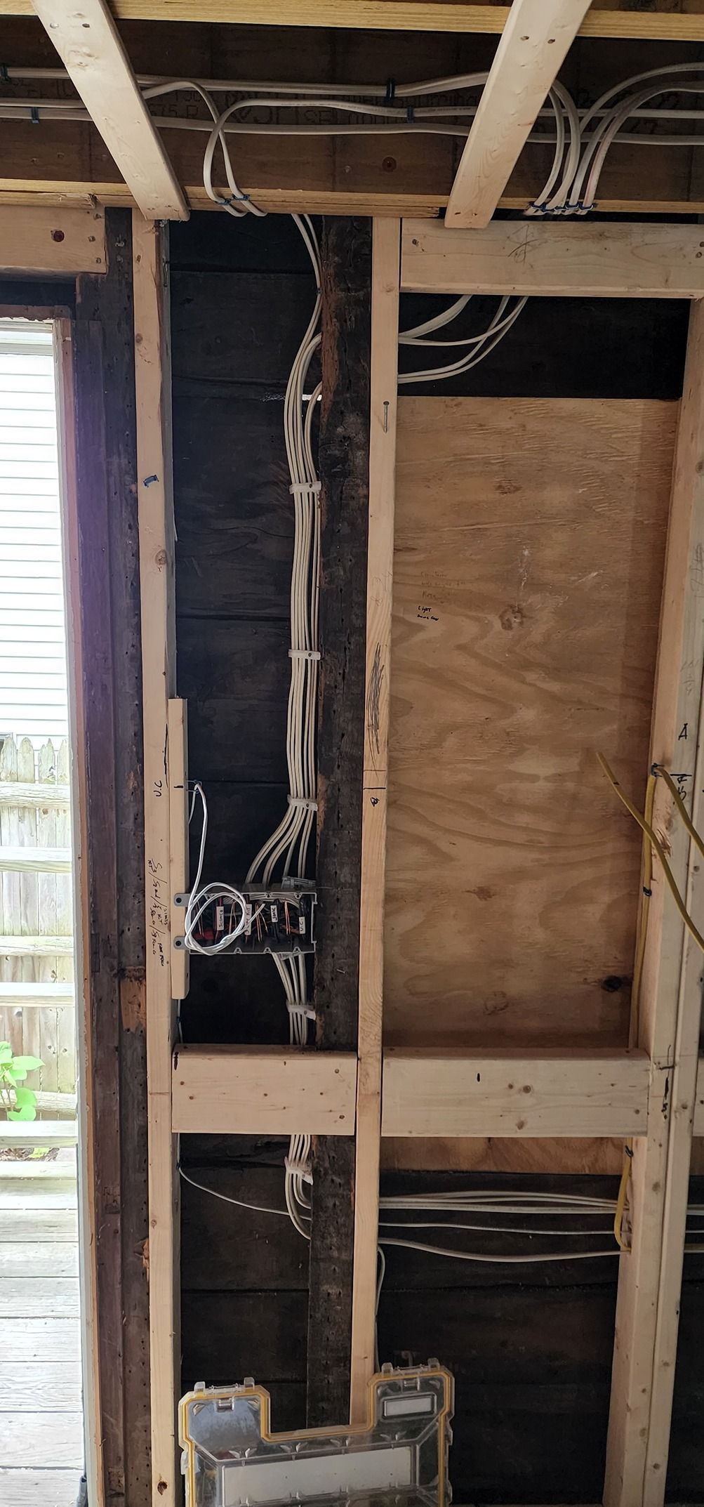 A wooden wall with electrical wires hanging from it.