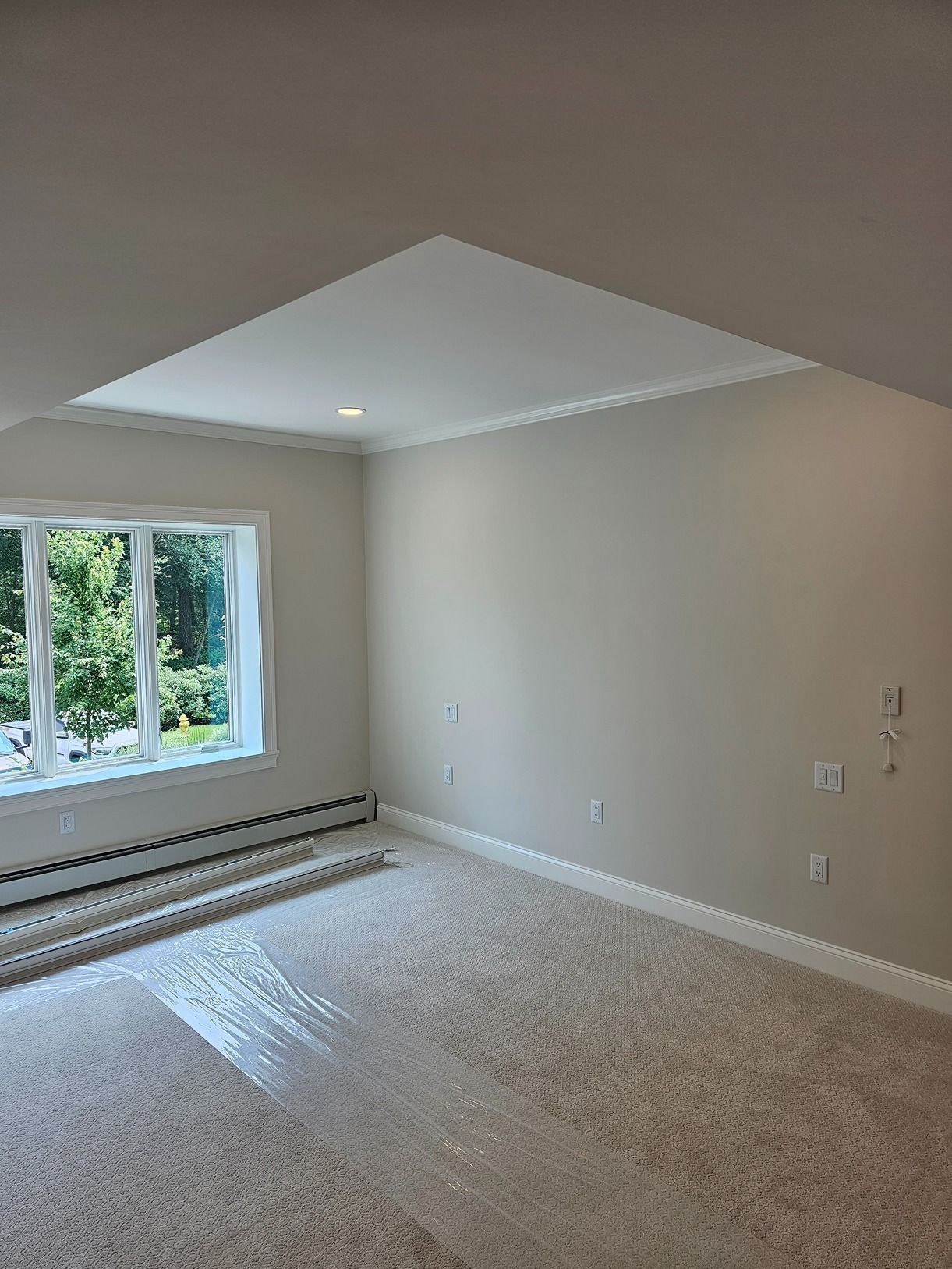 An empty room with a window and a ceiling.