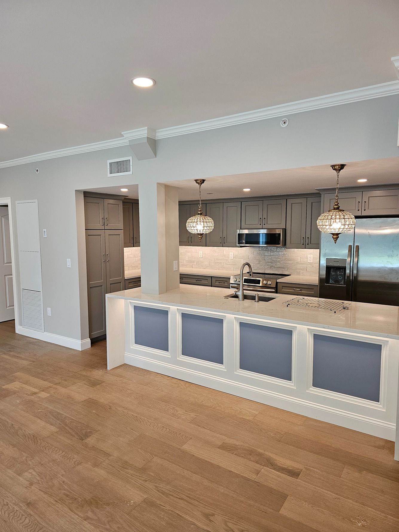 A kitchen with a large island and stainless steel appliances.