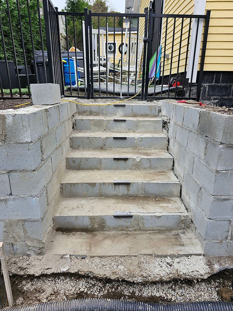 A set of concrete stairs leading up to a house.