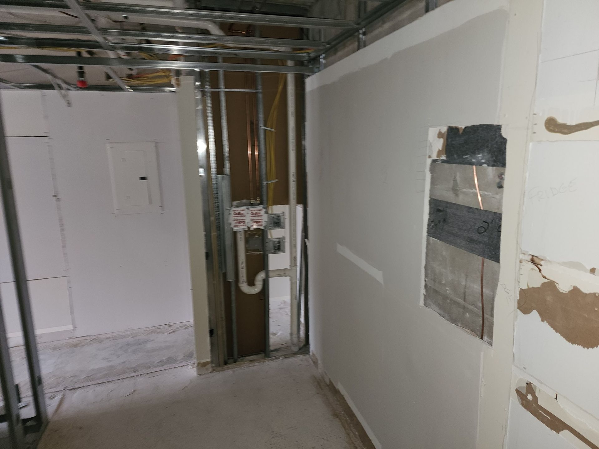 A hallway with white walls and a pipe that says ' eee ' on it