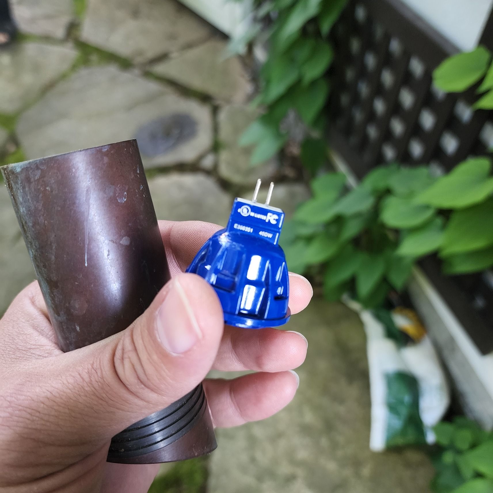 A person is holding a small blue object in their hand