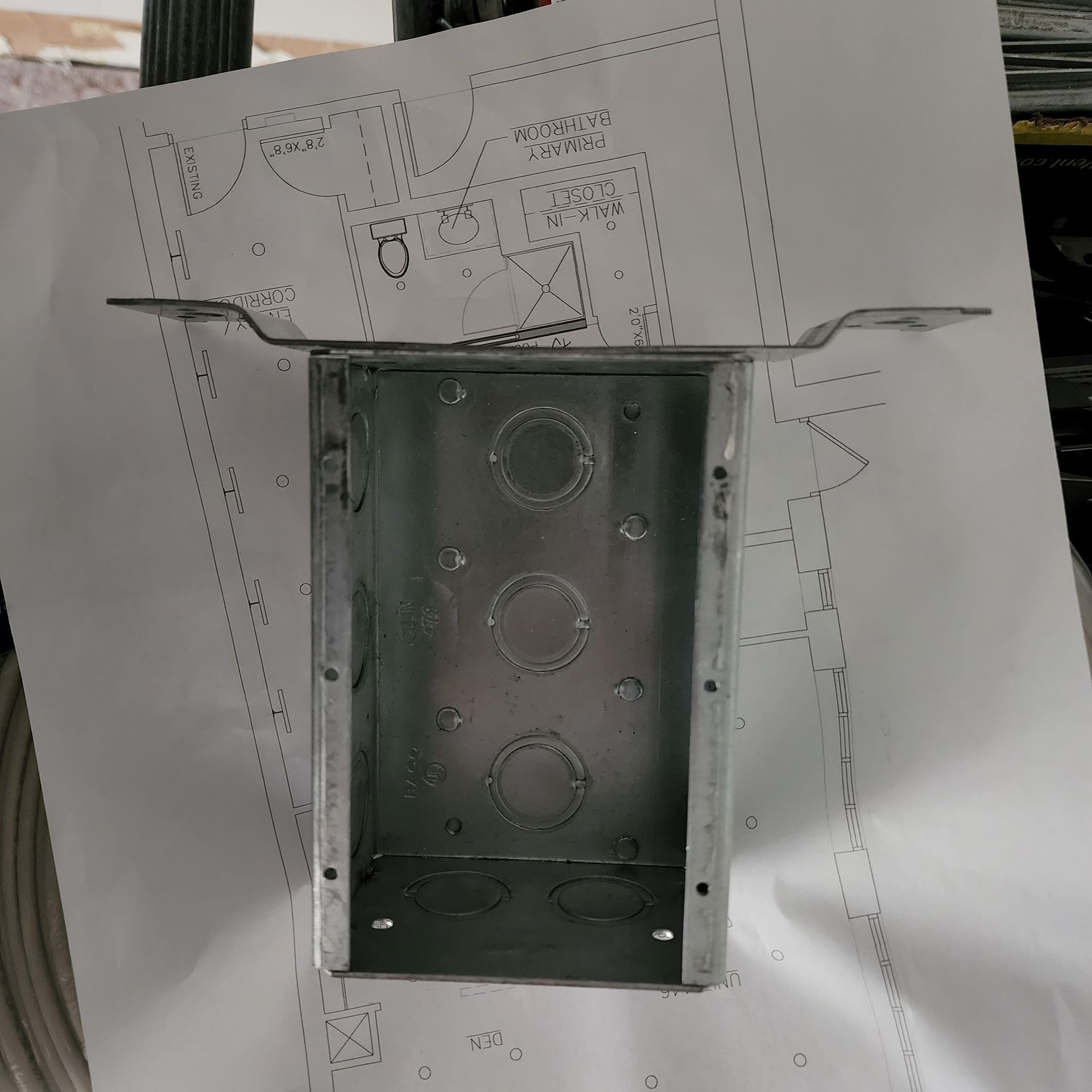 A metal box is sitting on top of a piece of paper