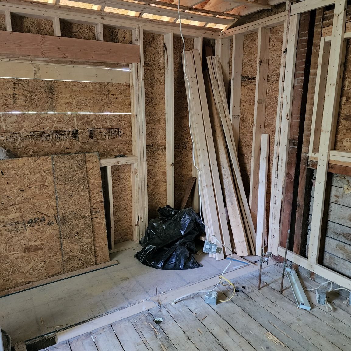 A room with a lot of wood and a black bag on the floor