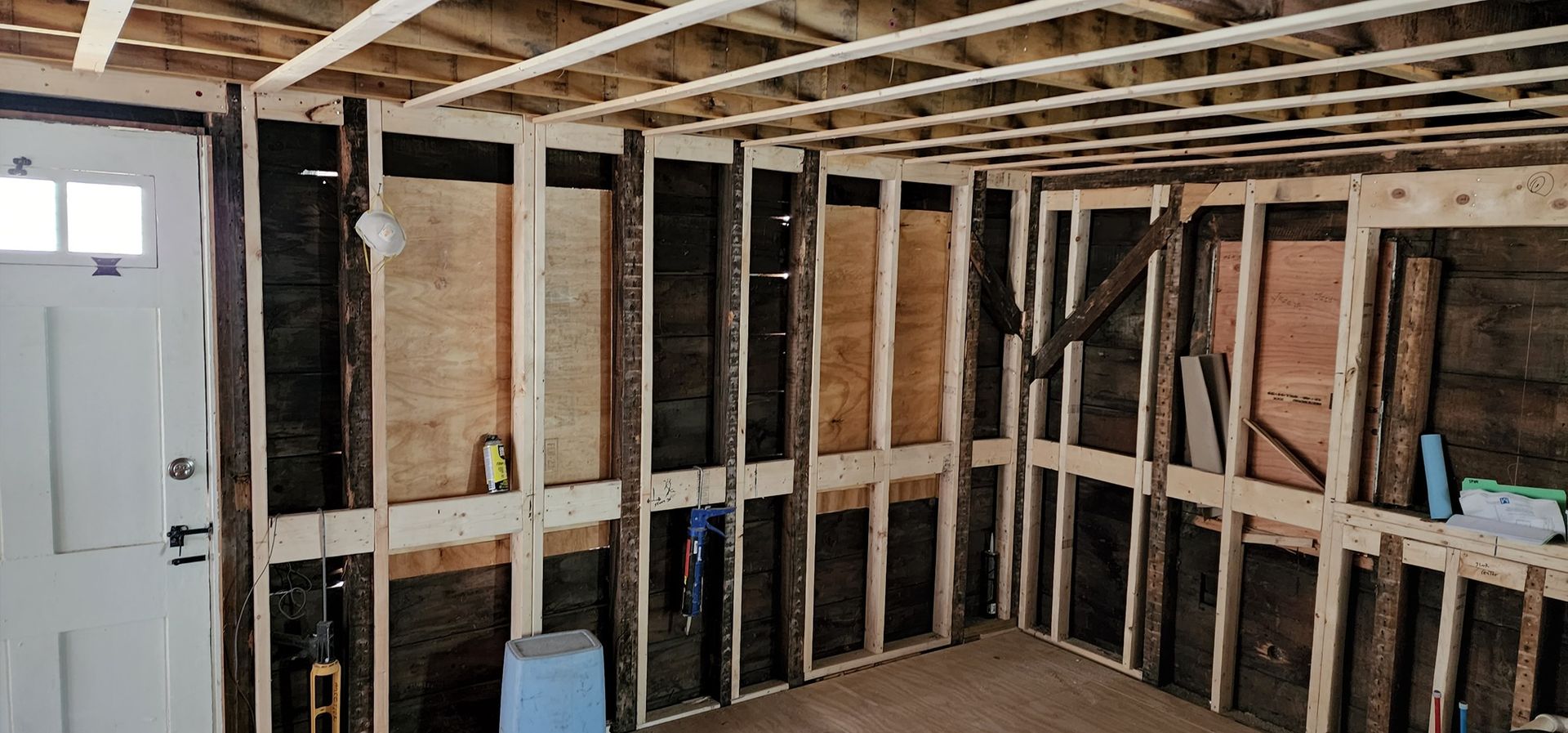 A room with a door and a lot of wooden frames.