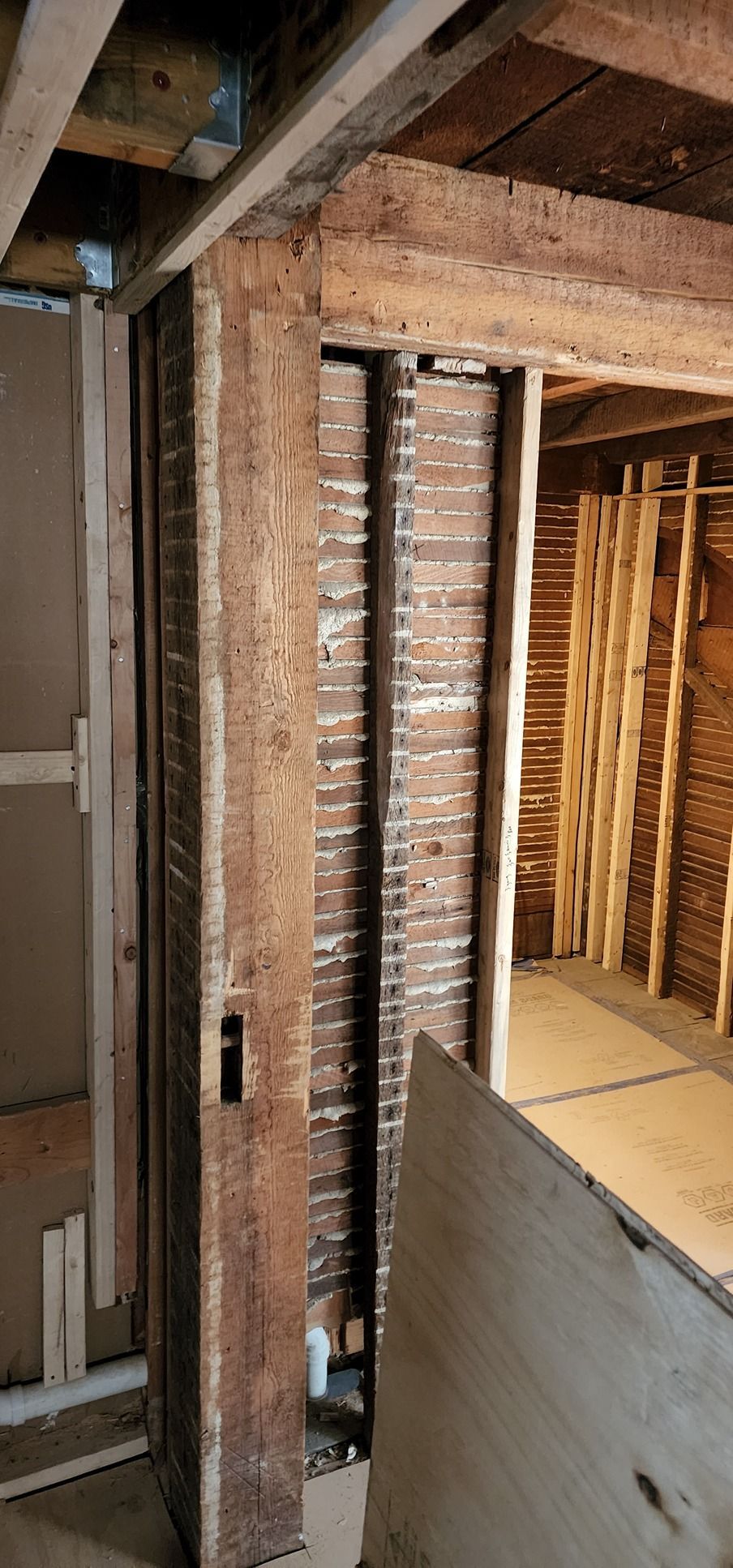 A room with a brick wall and wooden beams.