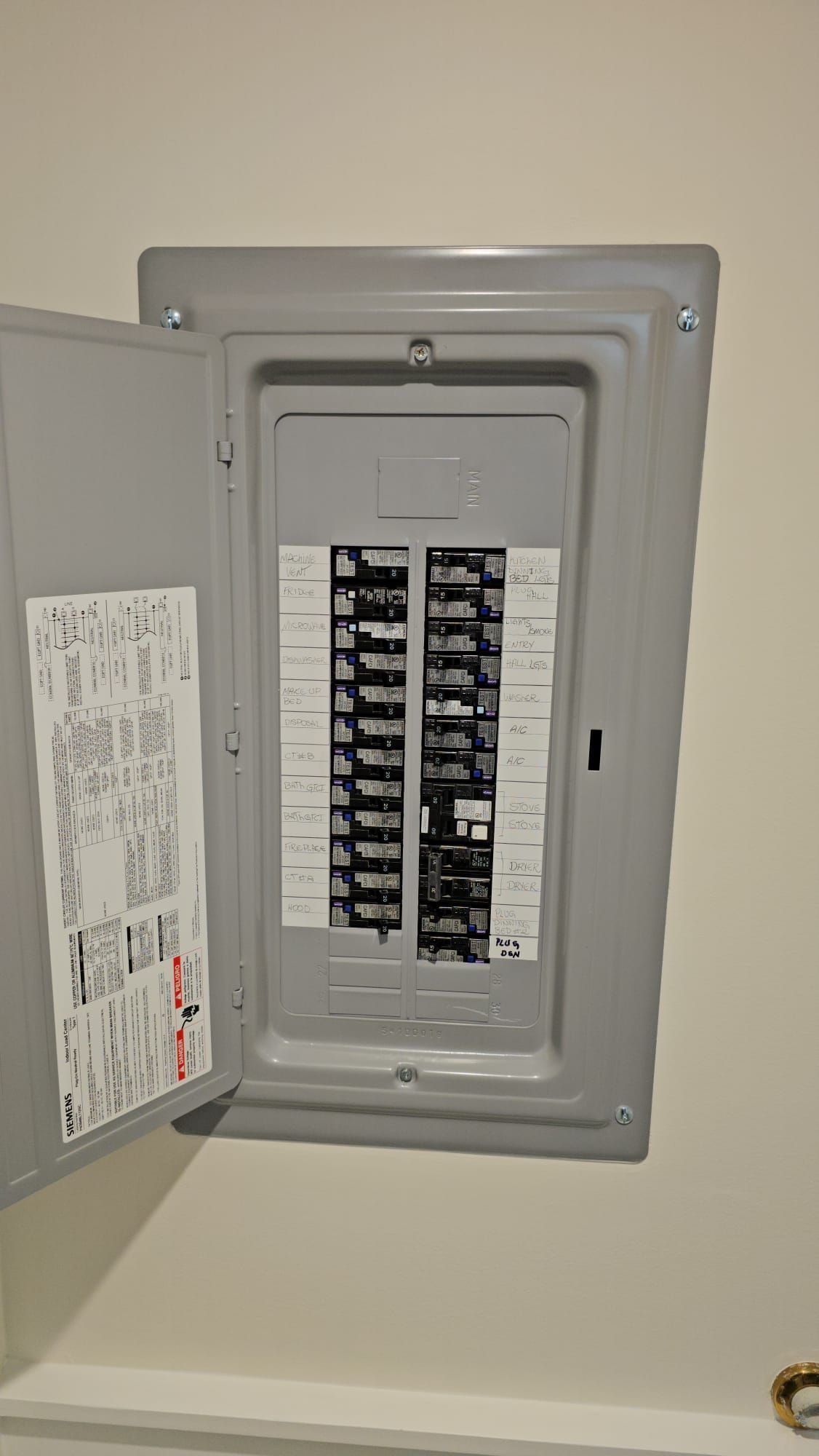 A kitchen with blue cabinets , white counter tops , and wooden shelves
