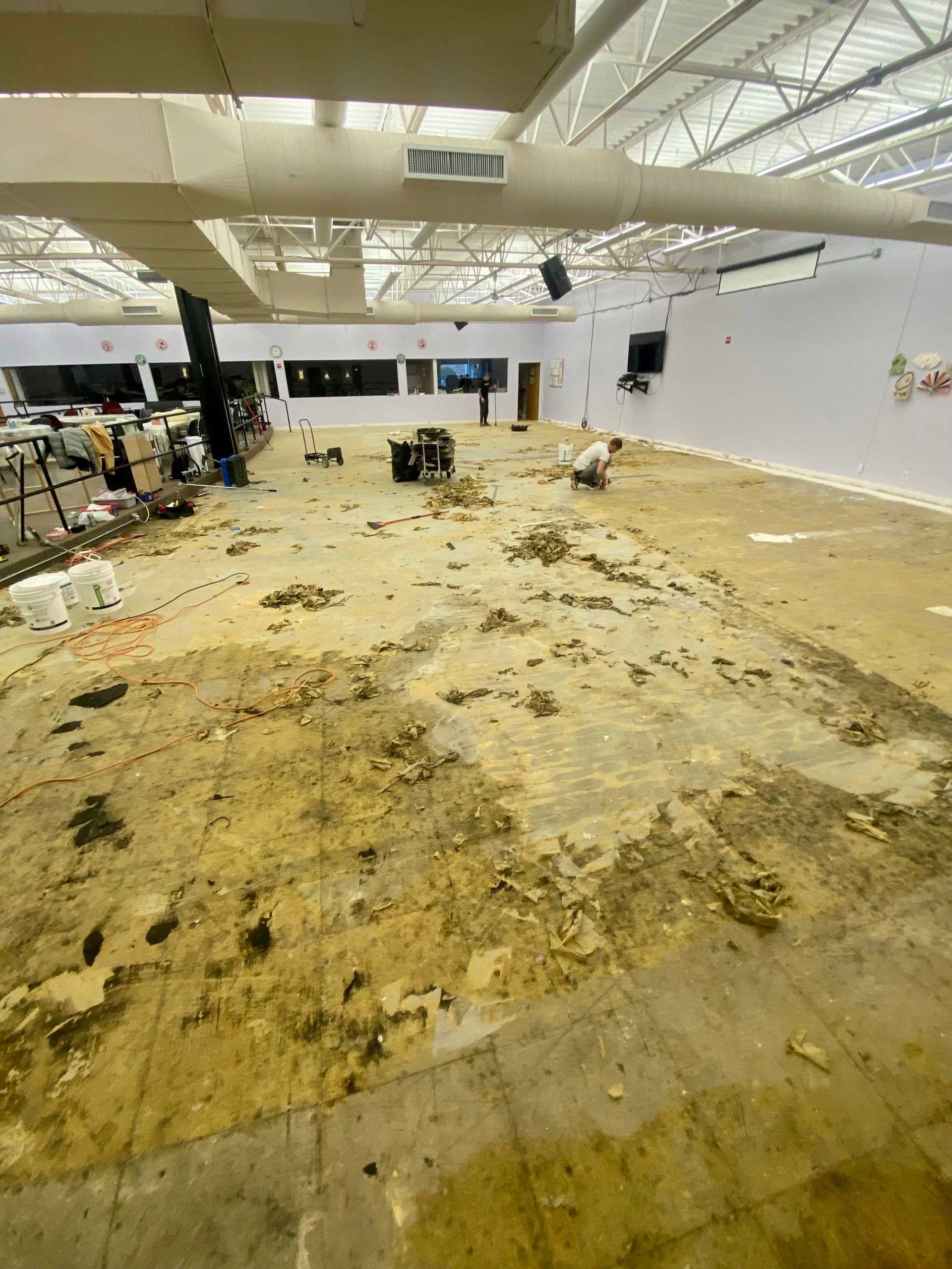 Interior of a room in disrepair. Debris covers the floor, walls and ceiling are damaged.