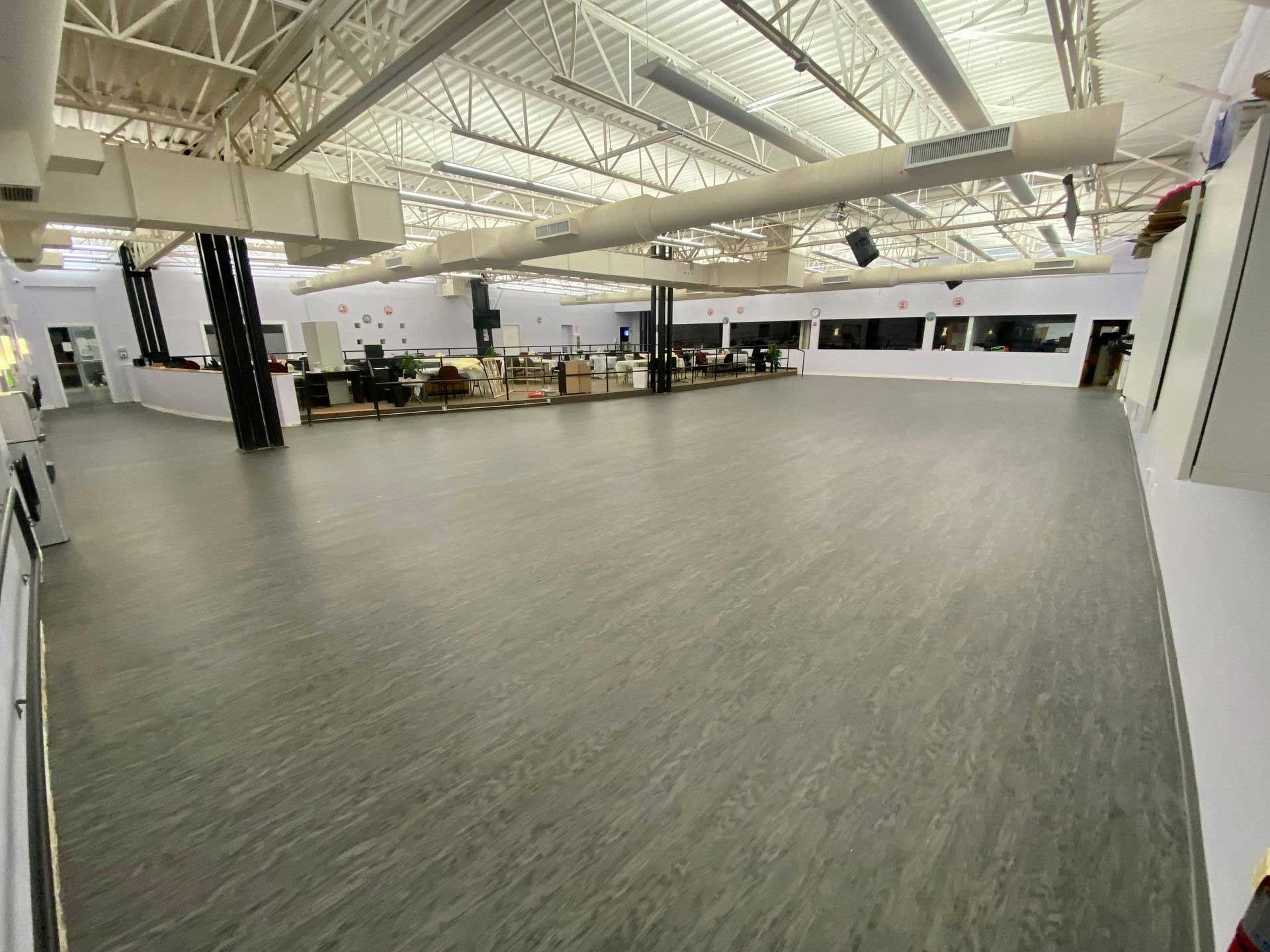 Large empty room with a gray floor and white ceiling.