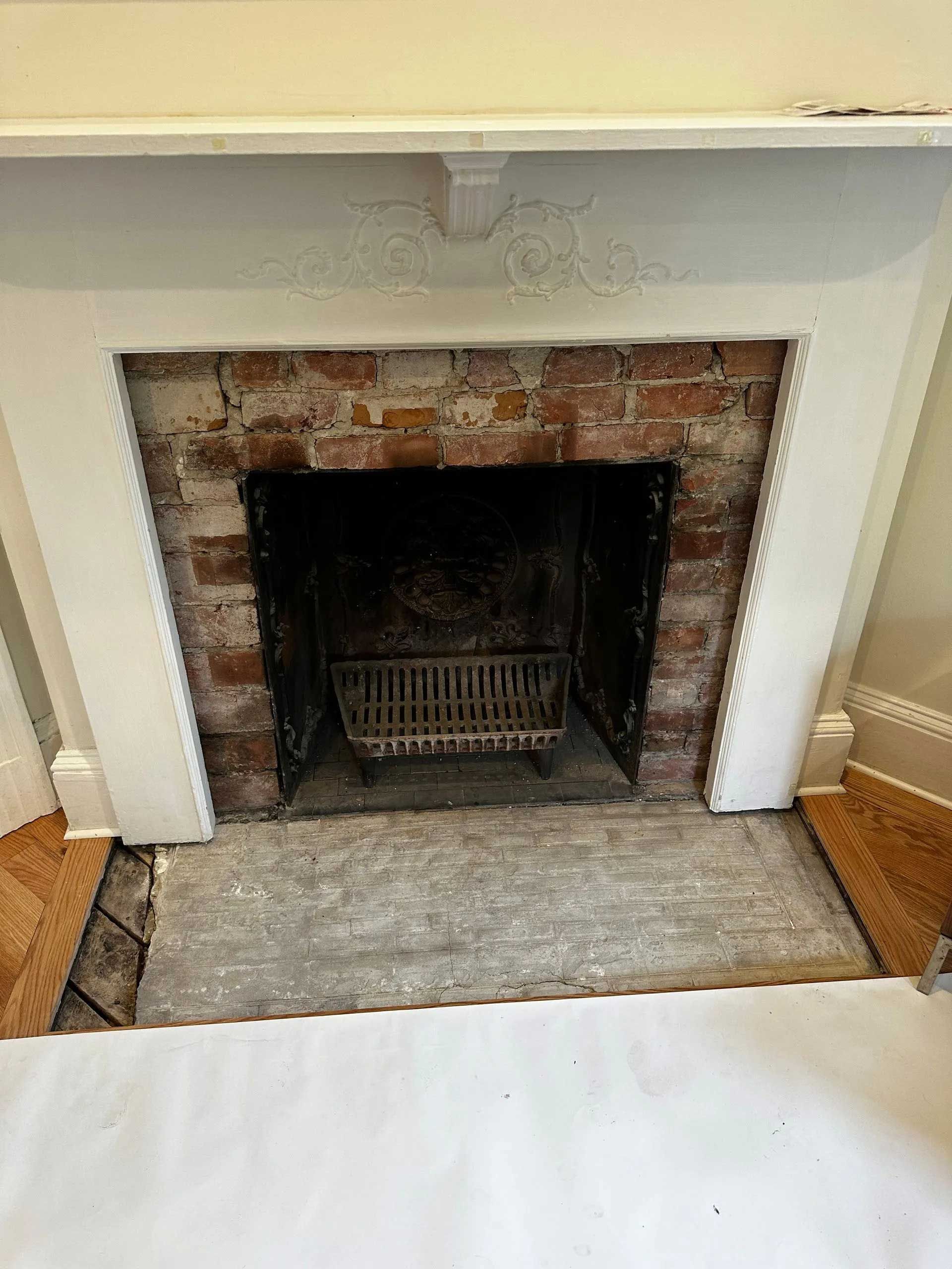 Brick fireplace with white trim and a dark interior.